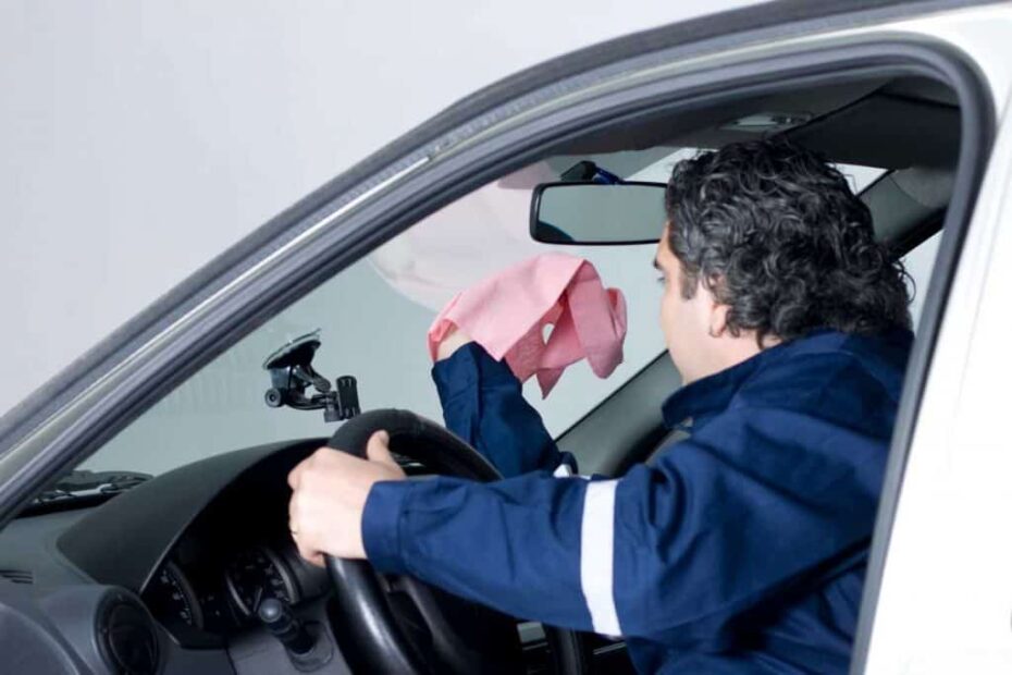 A man cleaning the inside of the windshield using colored pink microfiber cloth 1024x683 1