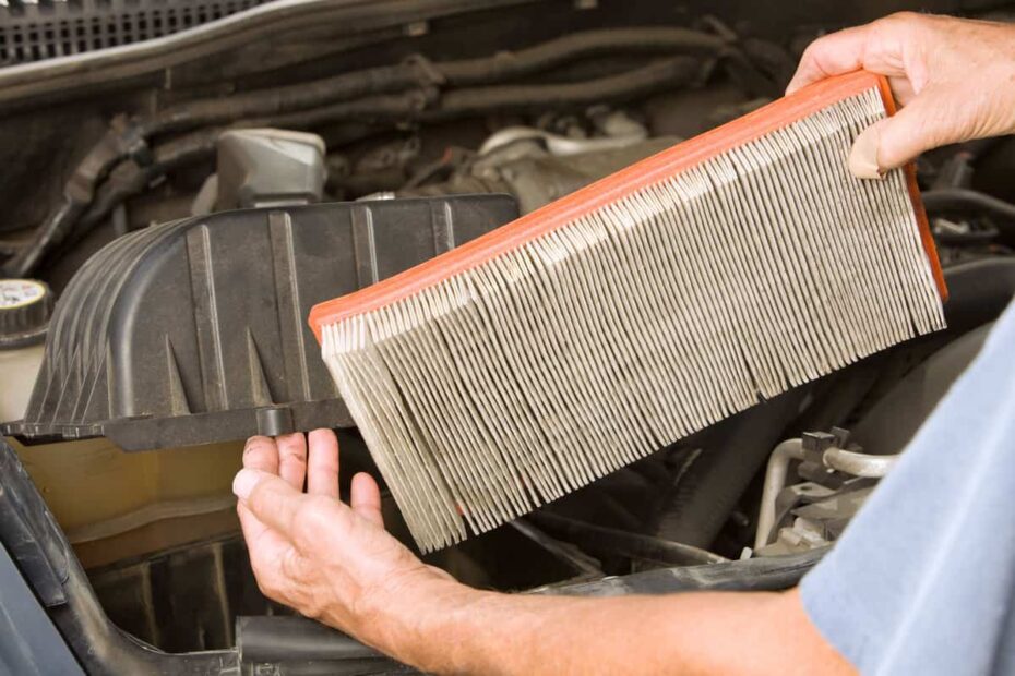 A mechanic removing an old dirty air filter